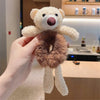 a person holding a teddy bear in a kitchen 