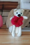 a teddy bear with a red bow sitting on a table 